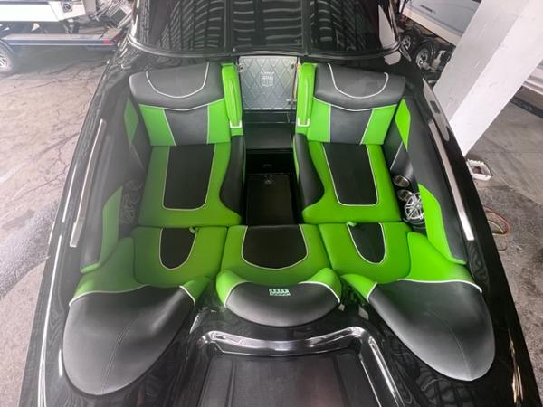 Slide: The Image of 2013 MasterCraft XStar boat with green and black interior seating. - 9