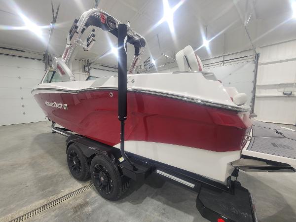 Slide: The Image of 2024 MasterCraft XT24 boat in a showroom, red and white exterior. - 21