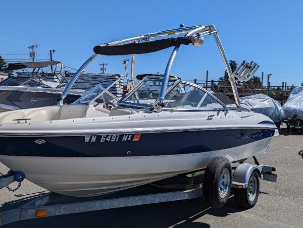 Slide: The Image of 2007 Maxum 1800 SR3 boat on trailer, parked outdoors under clear sky. - 0