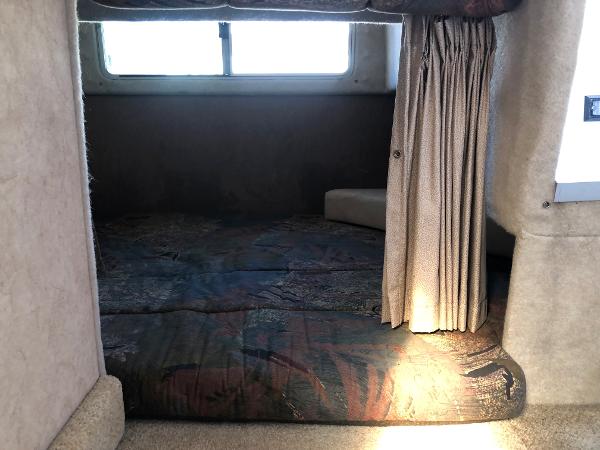 Slide: The Image of Cozy cabin interior of 1992 Maxum 2300 SCR boat with window and curtain. - 10