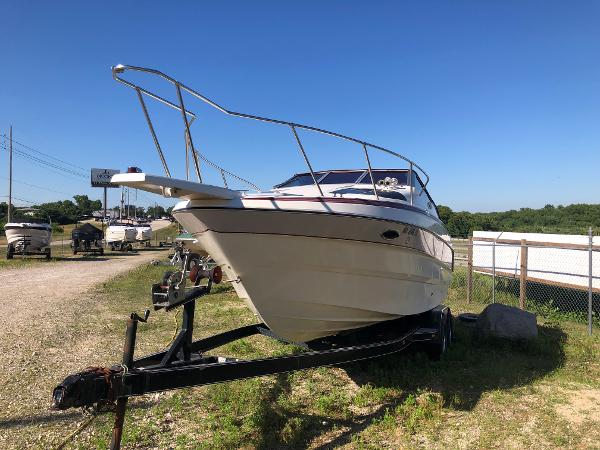 Slide: The Image of 1992 Maxum 2300 SCR boat on trailer, parked outdoors under clear blue sky. - 3