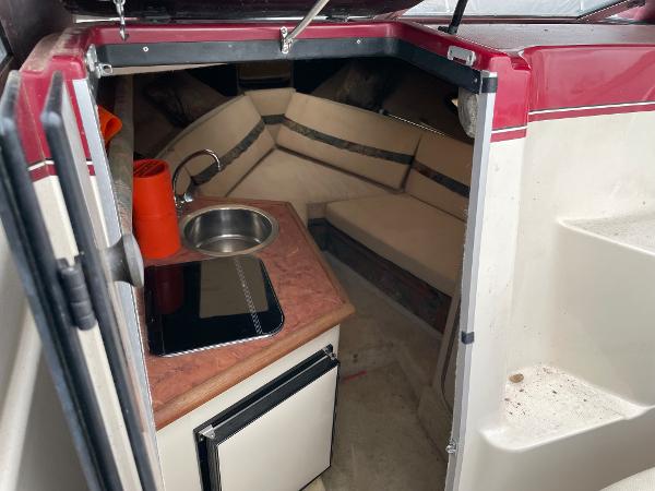 Slide: The Image of 1992 Maxum 2300 SCR cabin interior with kitchenette, sink, and seating area. - 4