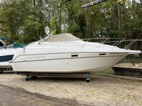 Slide: The Image of 2000 Maxum 2400 SCR boat on dry dock with trees in the background. - 0