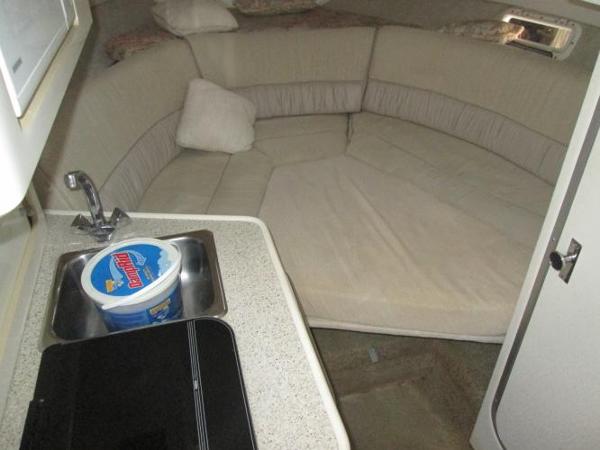 Slide: The Image of Interior of 2000 Maxum 2400 SCR boat with kitchenette and cushioned seating area. - 10