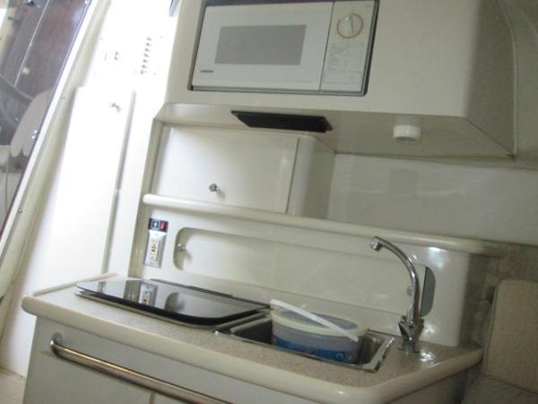 Slide: The Image of Compact kitchen area in a 2000 Maxum 2400 SCR boat with microwave and sink. - 14