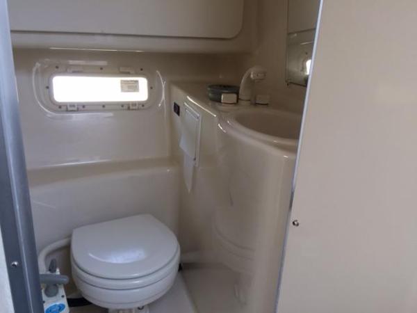 Slide: The Image of 2000 Maxum 2400 SCR boat bathroom with toilet, sink, and window. - 3