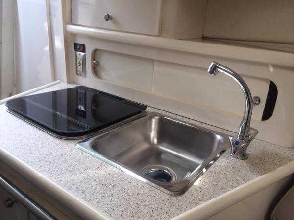 Slide: The Image of Compact kitchen area in a 2000 Maxum 2400 SCR boat with sink and stove. - 4