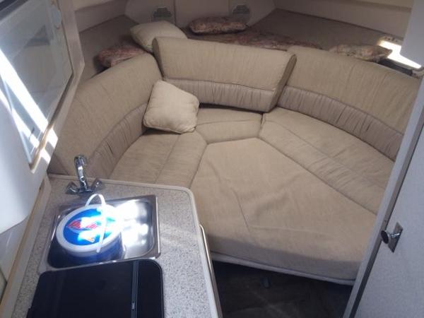 Slide: The Image of Interior cabin of a 2000 Maxum 2400 SCR boat with beige seating and kitchenette. - 6