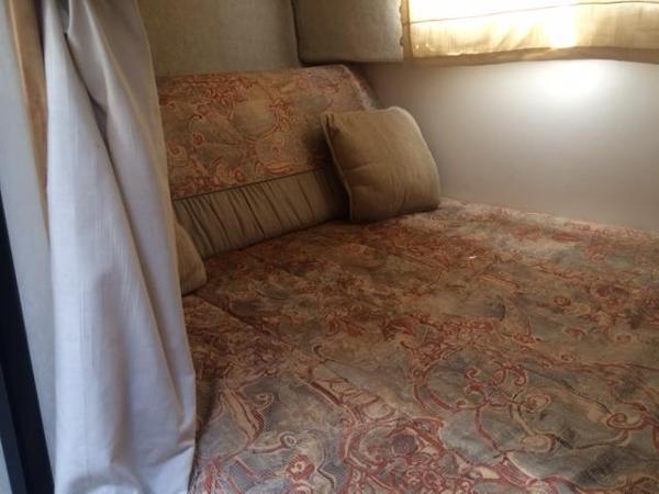 Slide: The Image of Cozy sleeping area in 2000 Maxum 2400 SCR boat with patterned bedding. - 7