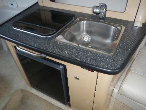 Slide: The Image of Compact kitchen area in a 2001 Maxum 2500 SCR boat with sink and mini-fridge. - 10