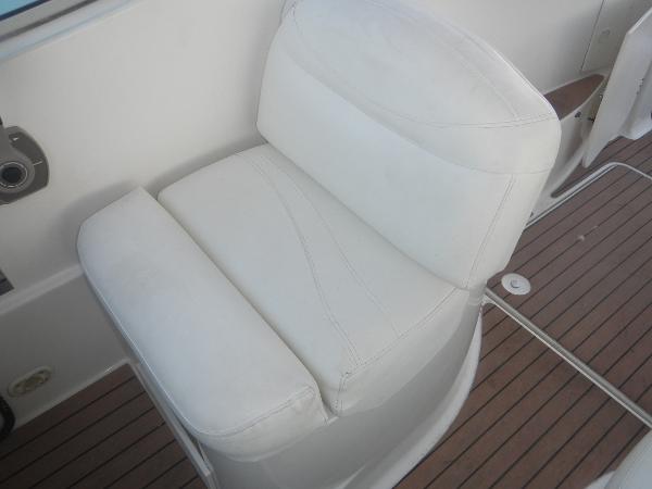 Slide: The Image of White cushioned seat on 2001 Maxum 2500 SCR boat with wooden deck. - 13