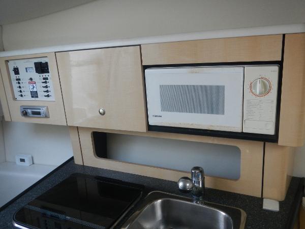 Slide: The Image of 2001 Maxum 2500 SCR boat kitchen with microwave, sink, and control panel. - 9