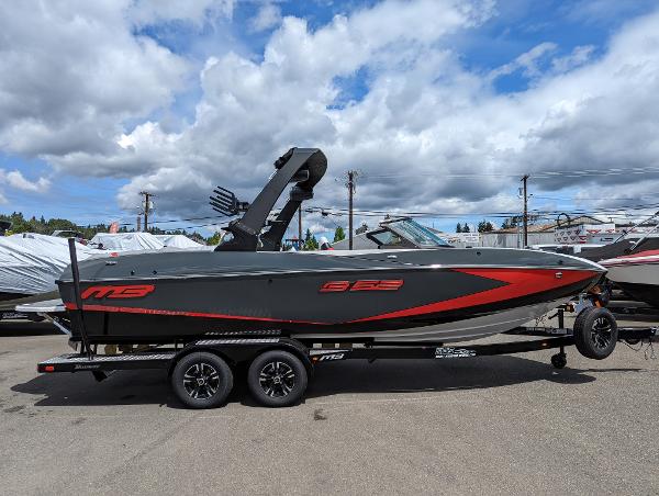 Slide: The Image of 2022 MB B52-23 boat on trailer, gray with red accents, parked outdoors. - 1