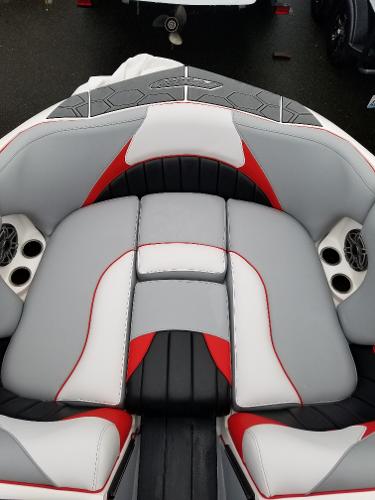 Slide: The Image of 2022 MB B52-23 boat interior with gray, red, and black seating and cup holders. - 17