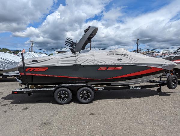 Slide: The Image of 2022 MB B52-23 boat on trailer with cover, parked outdoors under cloudy sky. - 4