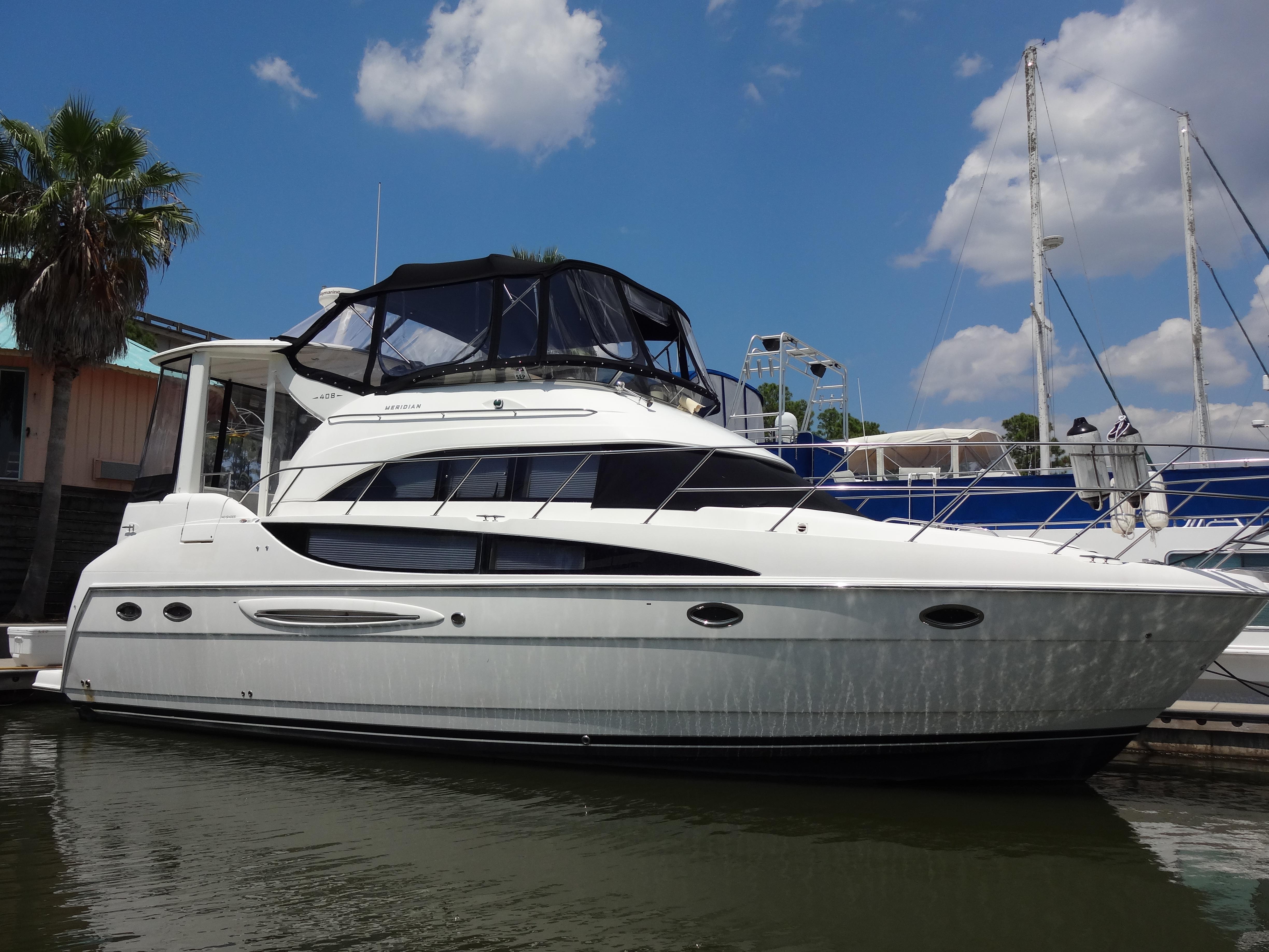 Slide: The Image of 2004 Meridian 408 Motoryacht docked at marina under blue sky. - 0