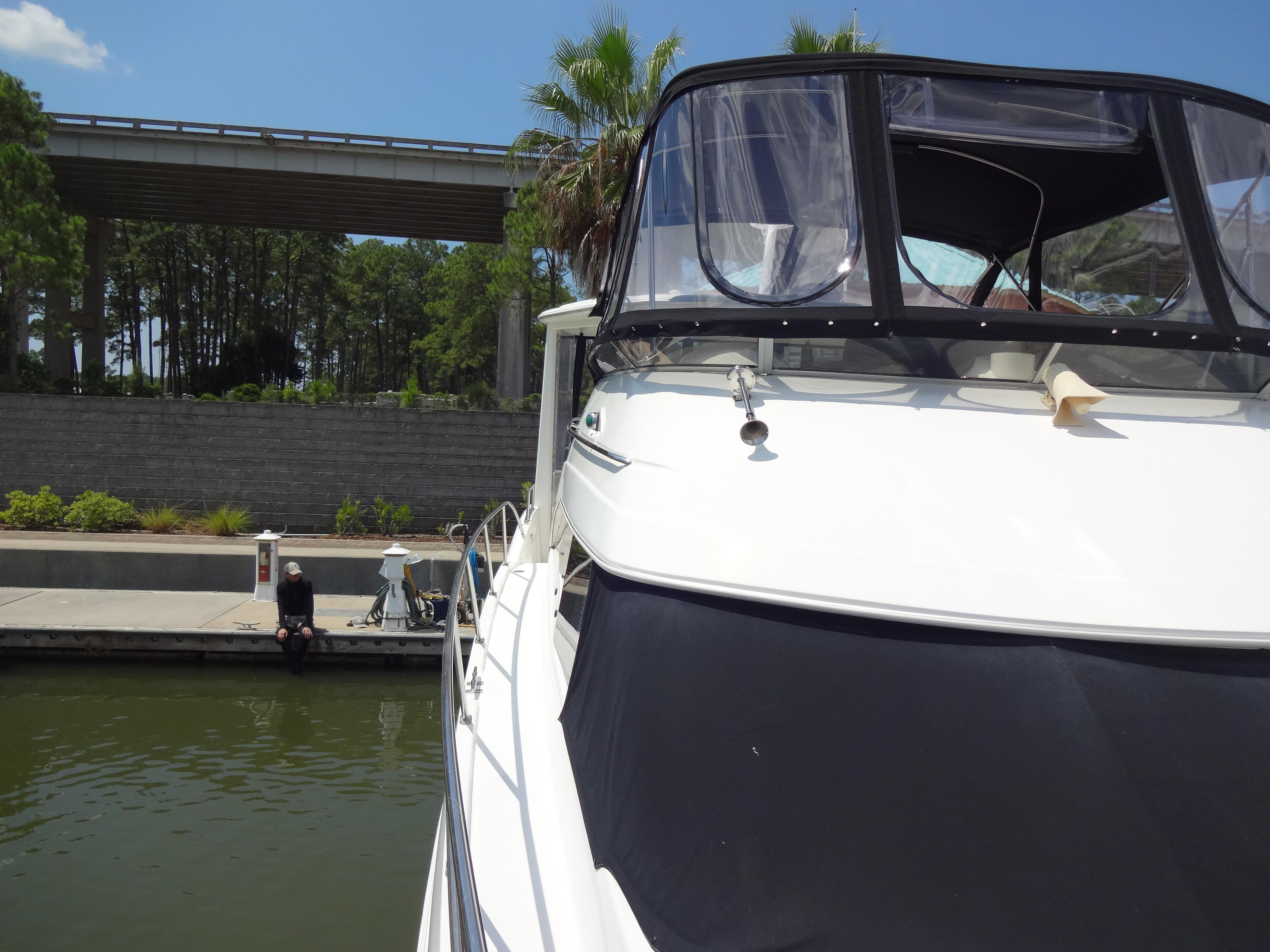 Slide: The Image of 2004 Meridian 408 Motoryacht docked near a bridge with lush greenery. - 18