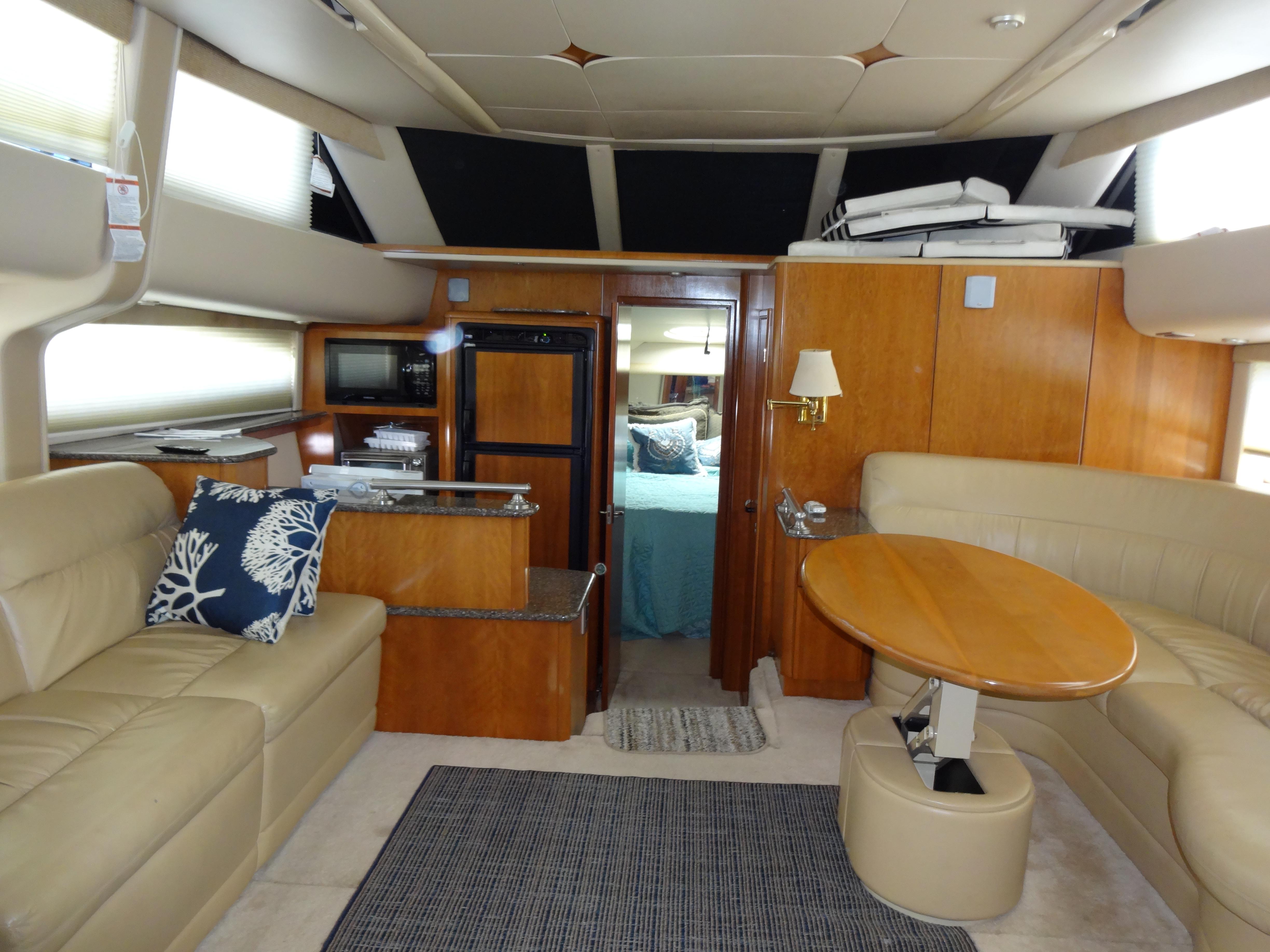 Slide: The Image of Interior of 2004 Meridian 408 Motoryacht with beige leather seating, wooden table, and kitchenette. - 30