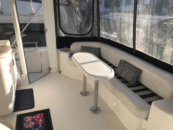 Slide: The Image of 2004 Meridian 459 Motoryacht interior with seating and table, featuring striped cushions. - 17
