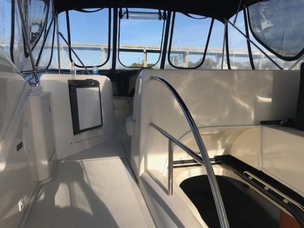 Slide: The Image of 2004 Meridian 459 Motoryacht interior with seating and railing, featuring clear windows and bright lighting. - 19