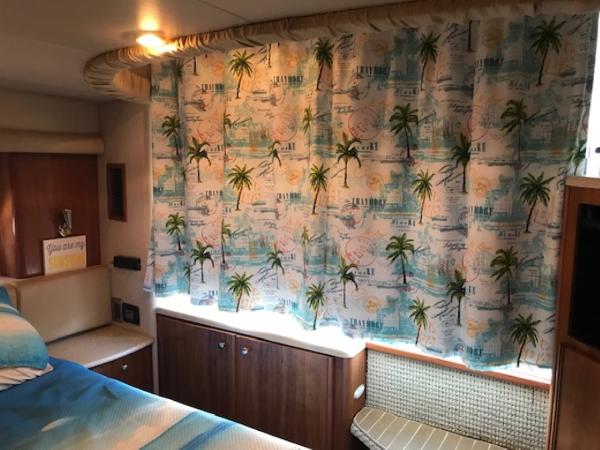 Slide: The Image of 2004 Meridian 459 Motoryacht interior with tropical-themed curtains and cozy cabin decor. - 31