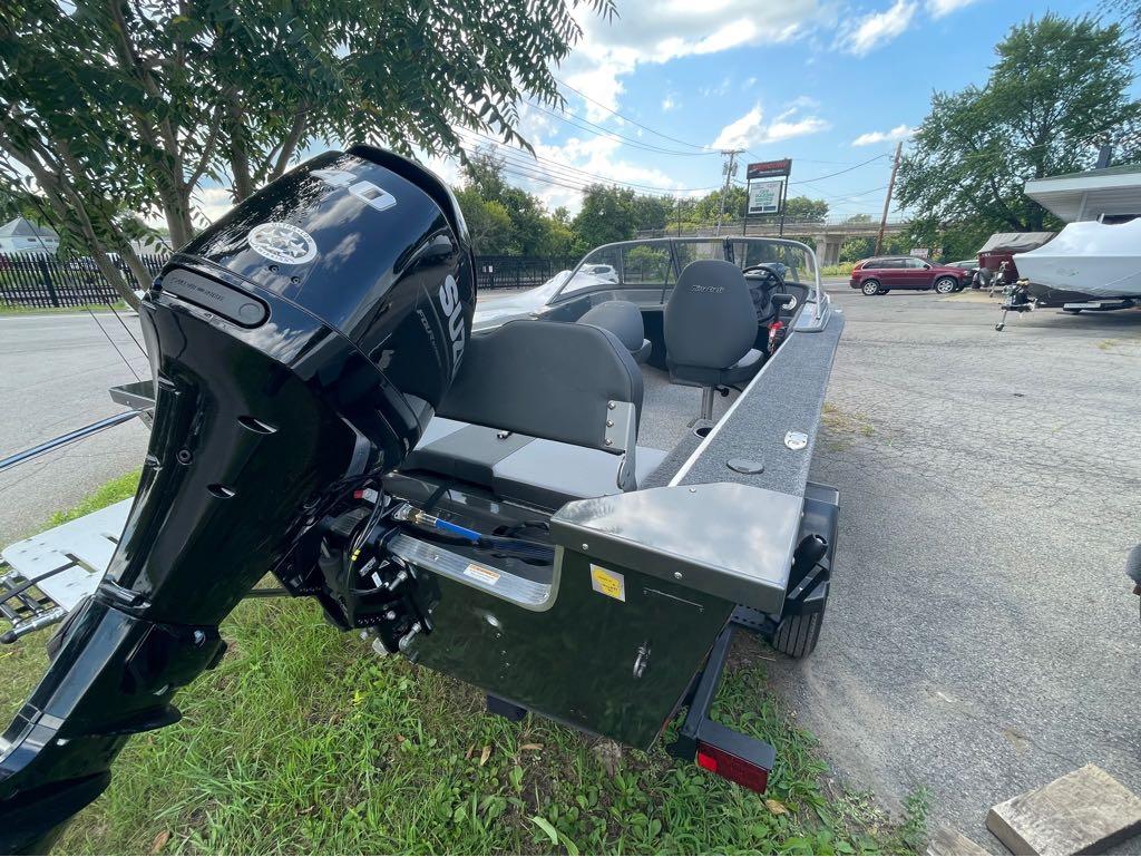 Slide: The Image of 2023 MirroCraft 1628 boat with Suzuki outboard motor in a parking lot. - 1