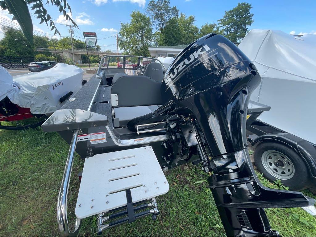 Slide: The Image of 2023 MirroCraft 1628 boat with Suzuki outboard motor, parked on grass. - 14