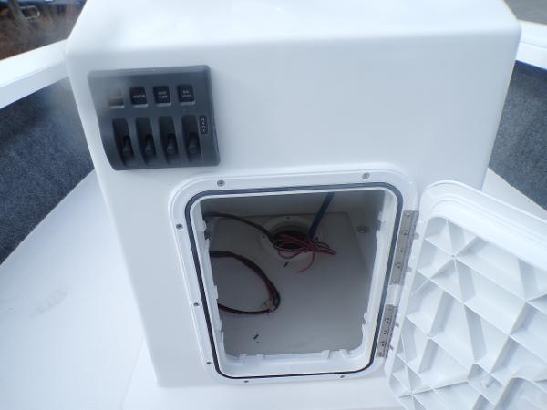 Slide: The Image of Open storage compartment and control panel on a 2024 Mitzi Skiffs 17cc boat. - 8