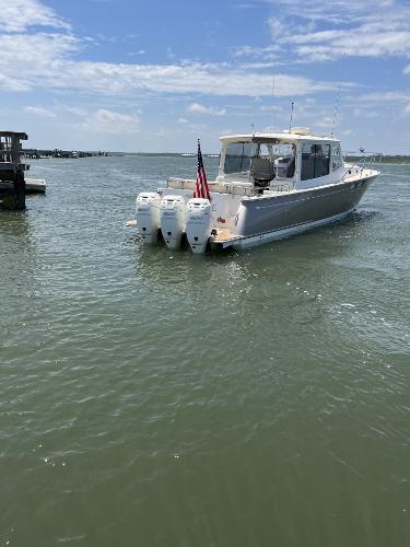 Slide: The Image of 2019 MJM 43z boat with triple outboard engines on calm water. - 42