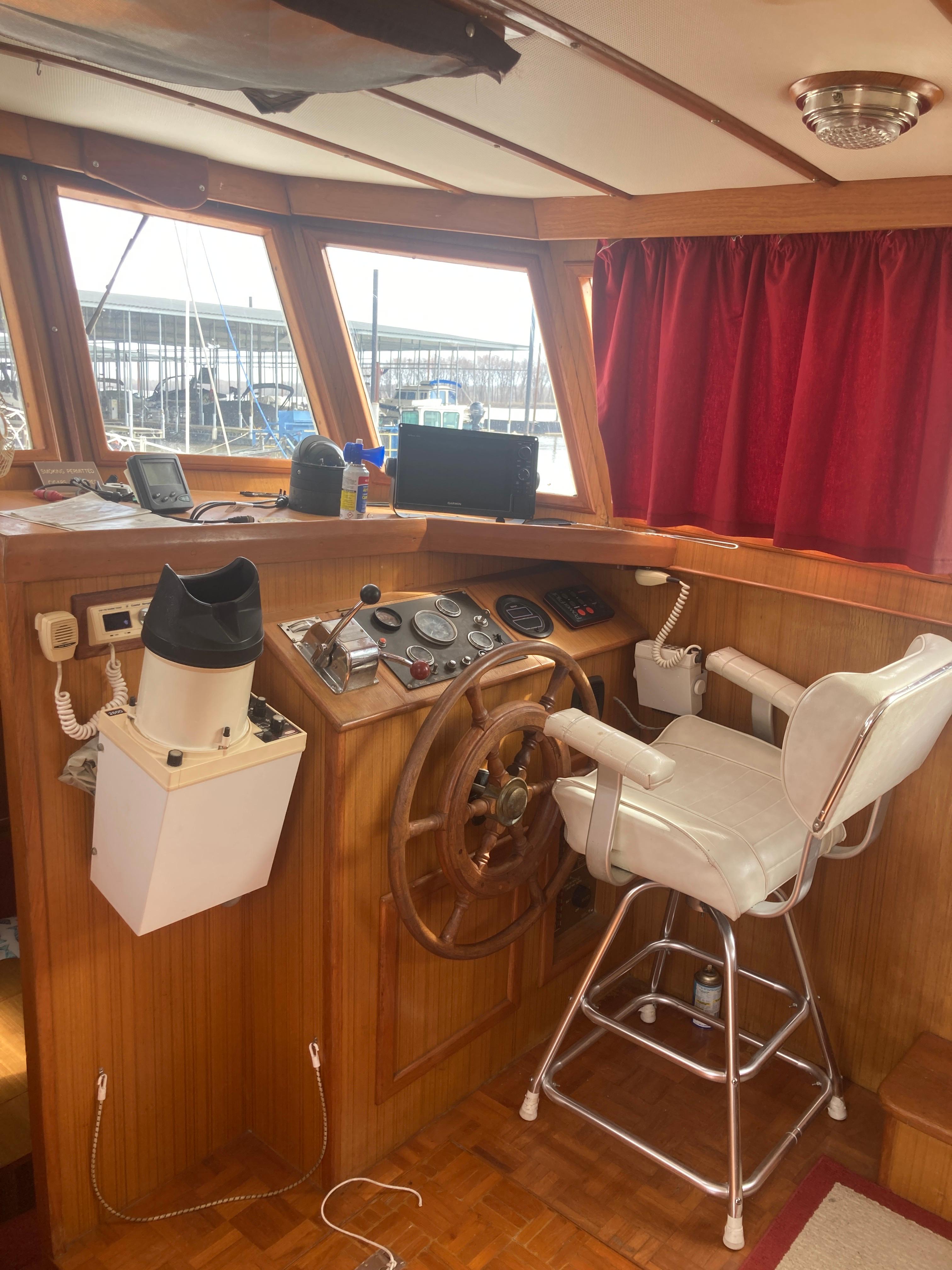 Slide: The Image of Interior helm of 1981 Monk Comfort Monk Motorsailer 38 with wooden wheel and white captain's chair. - 11