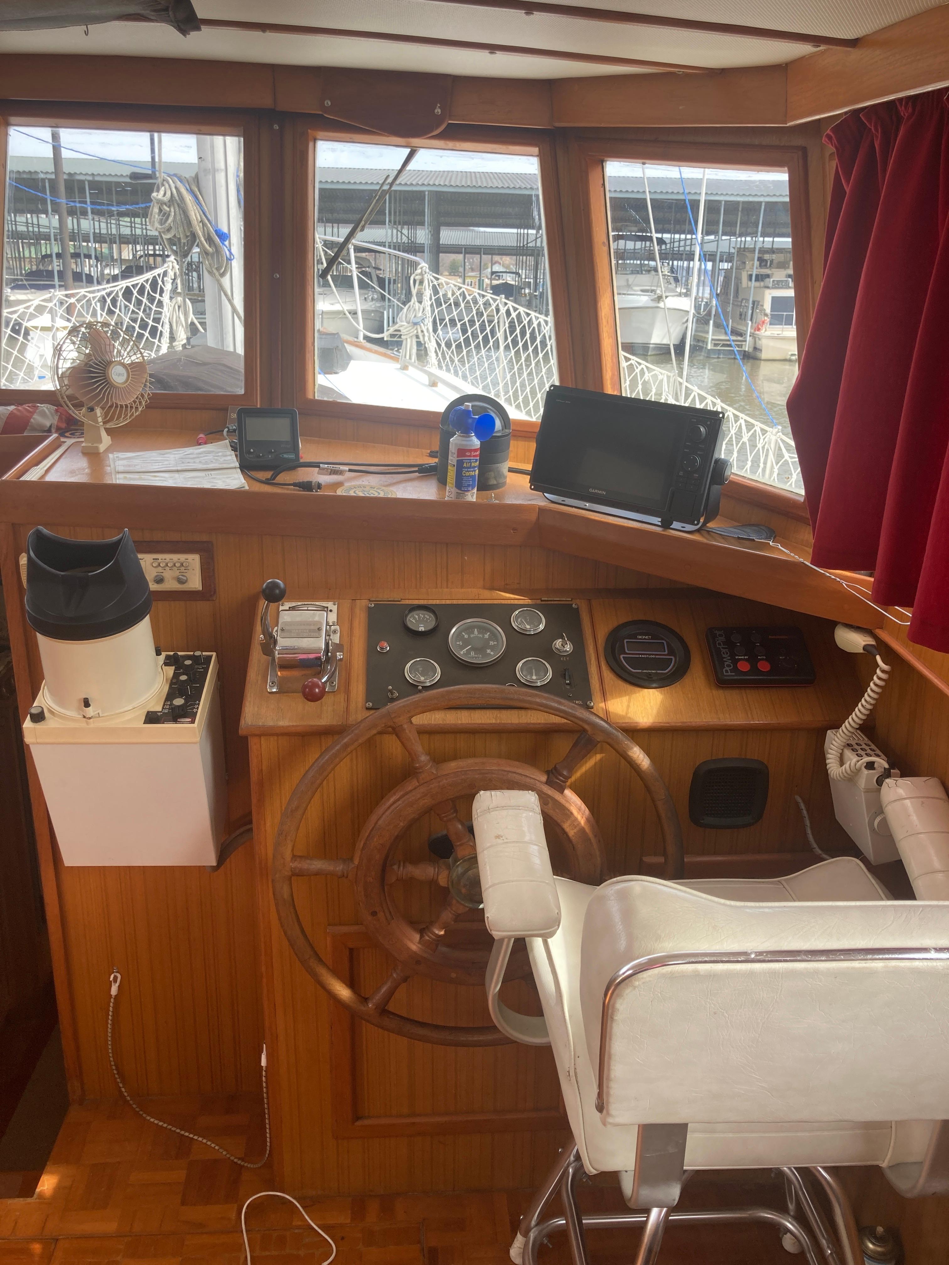 Slide: The Image of 1981 Monk Comfort Monk Motorsailer 38 helm station with wooden wheel and navigation equipment. - 12