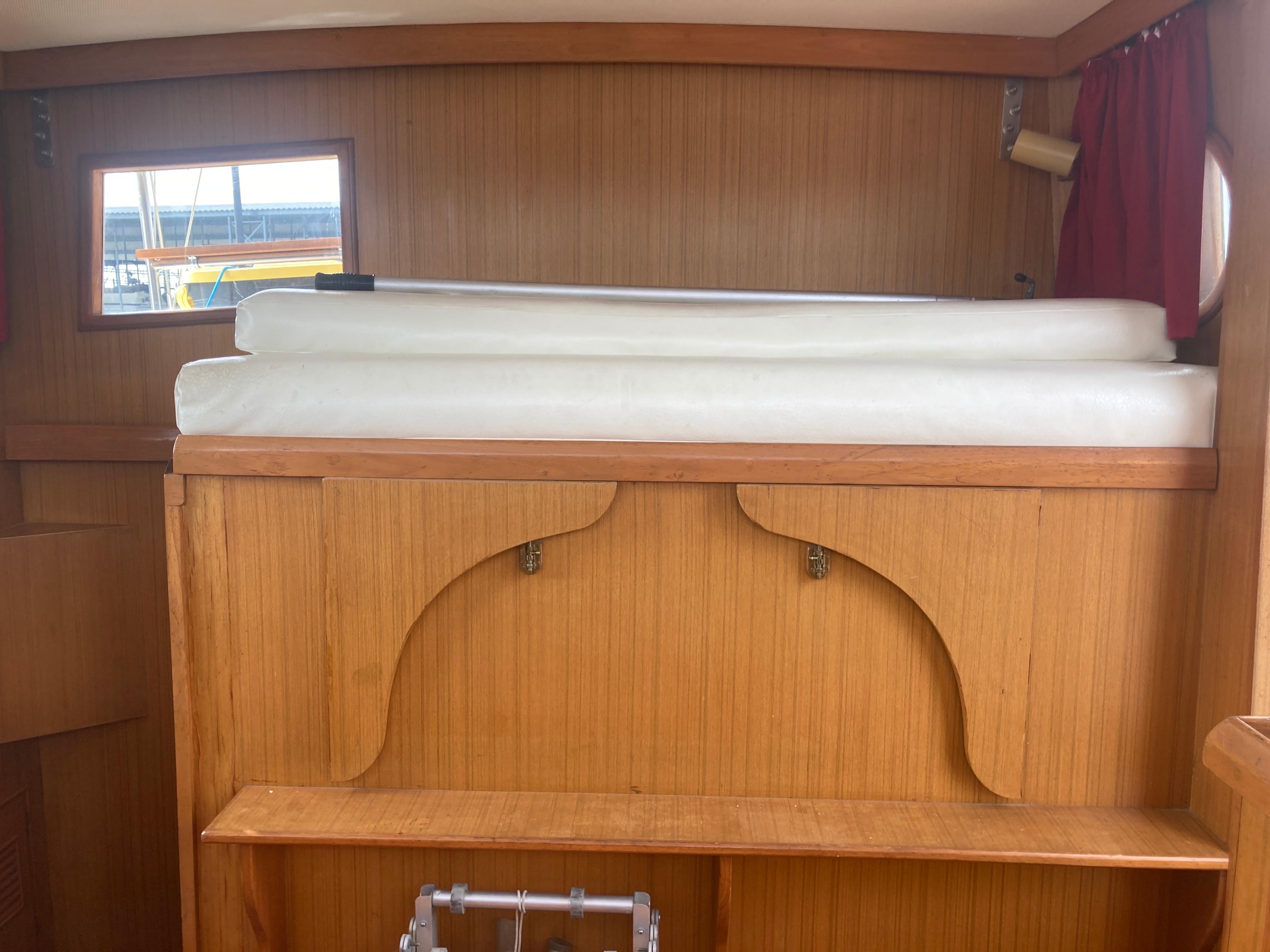 Slide: The Image of Interior cabin of 1981 Monk Comfort Monk Motorsailer 38 with wooden paneling and window. - 14