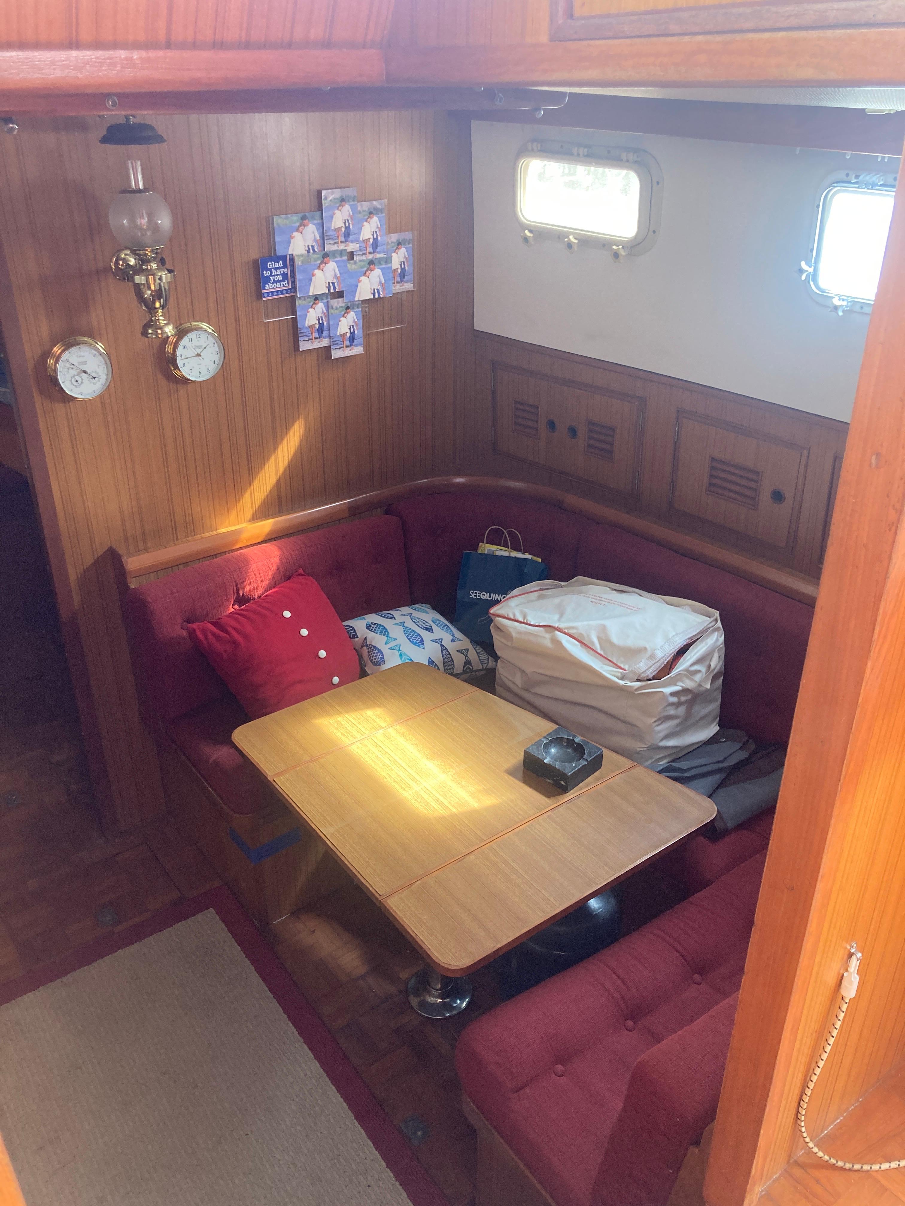 Slide: The Image of Interior of 1981 Monk Comfort Monk Motorsailer 38 with red seating and wooden table. - 16