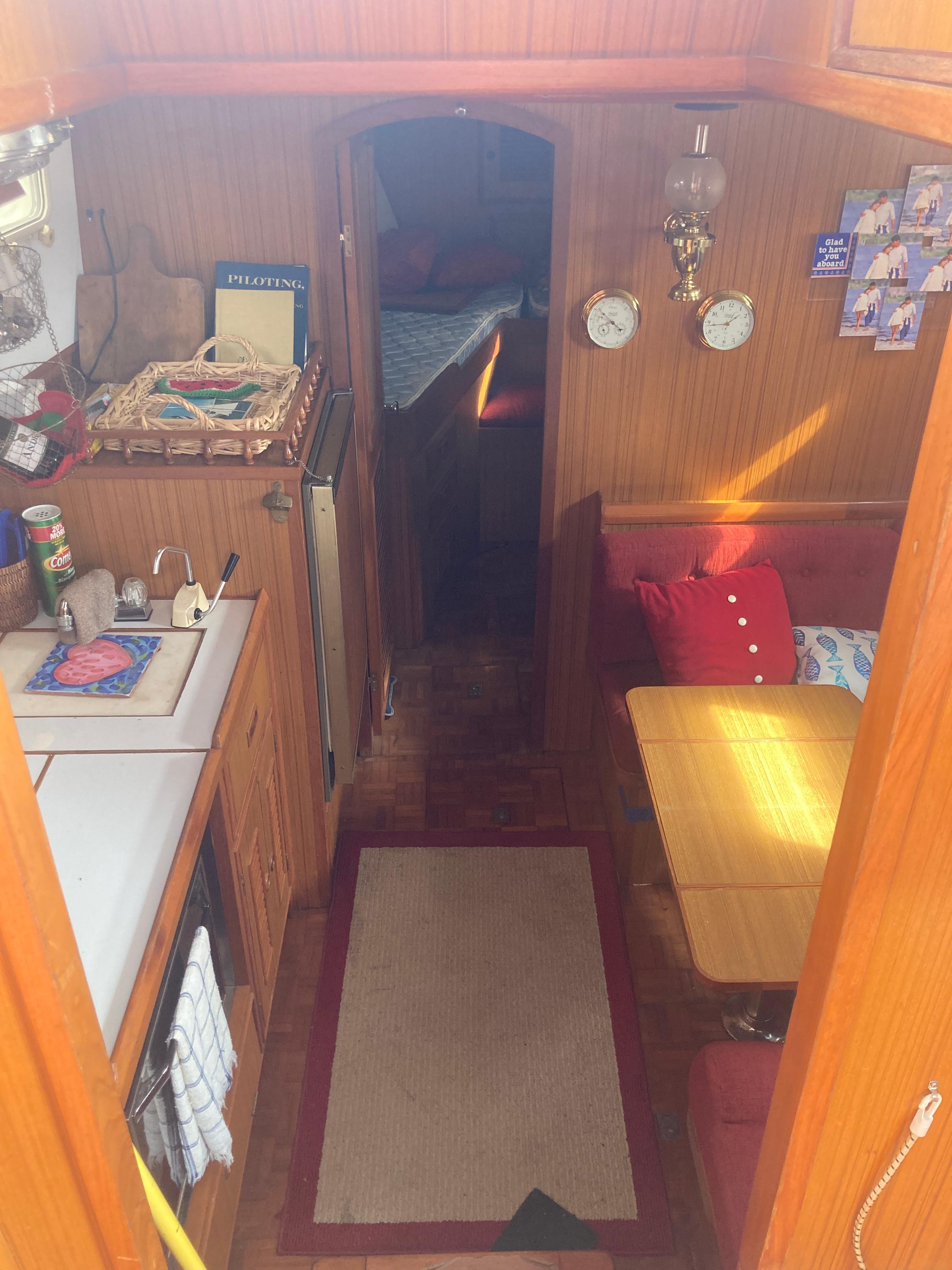 Slide: The Image of Interior of 1981 Monk Comfort Monk Motorsailer 38, featuring cozy dining and kitchen area. - 17
