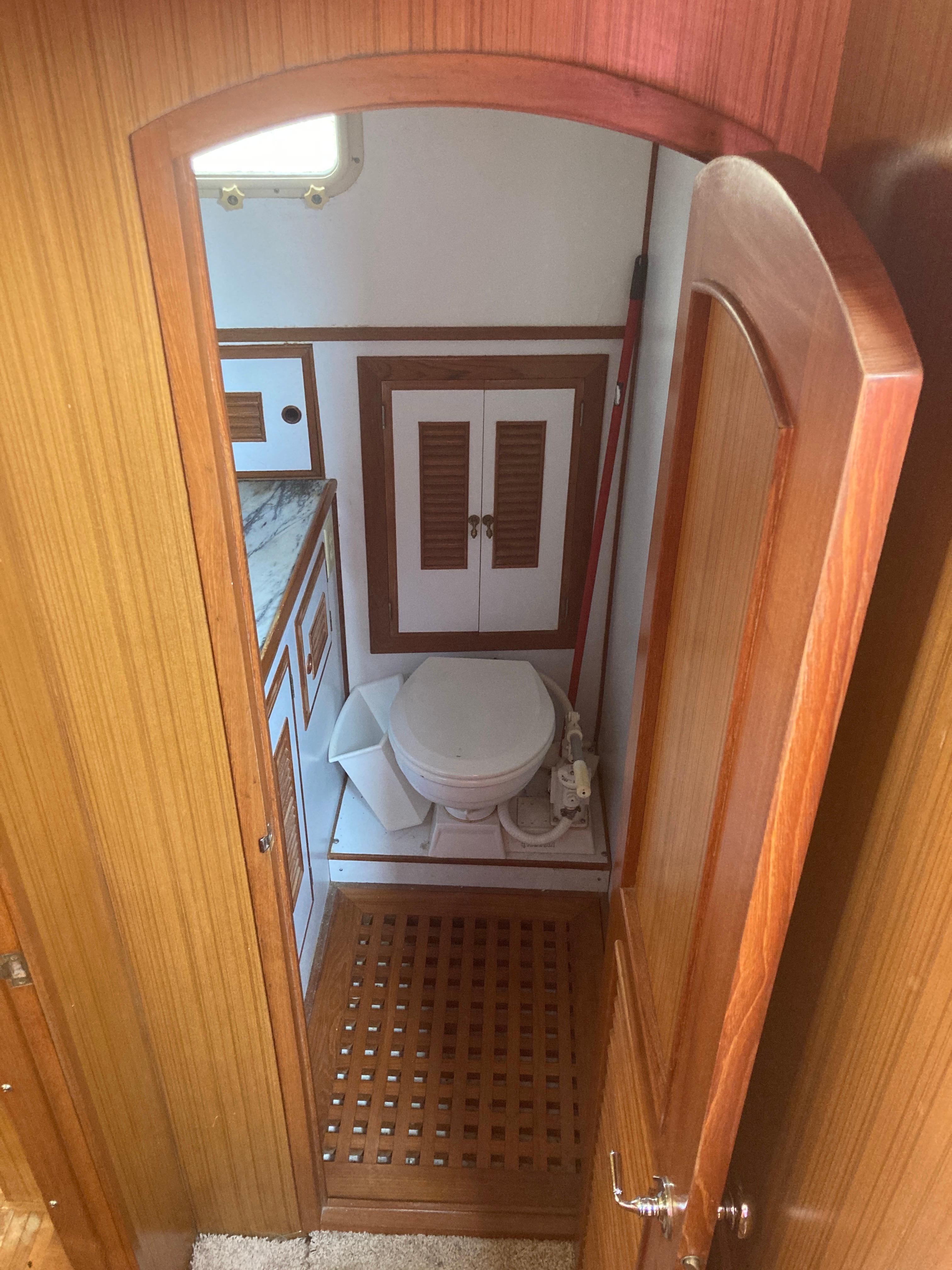 Slide: The Image of 1981 Monk Comfort Monk Motorsailer 38 bathroom with wooden accents and marine toilet. - 6