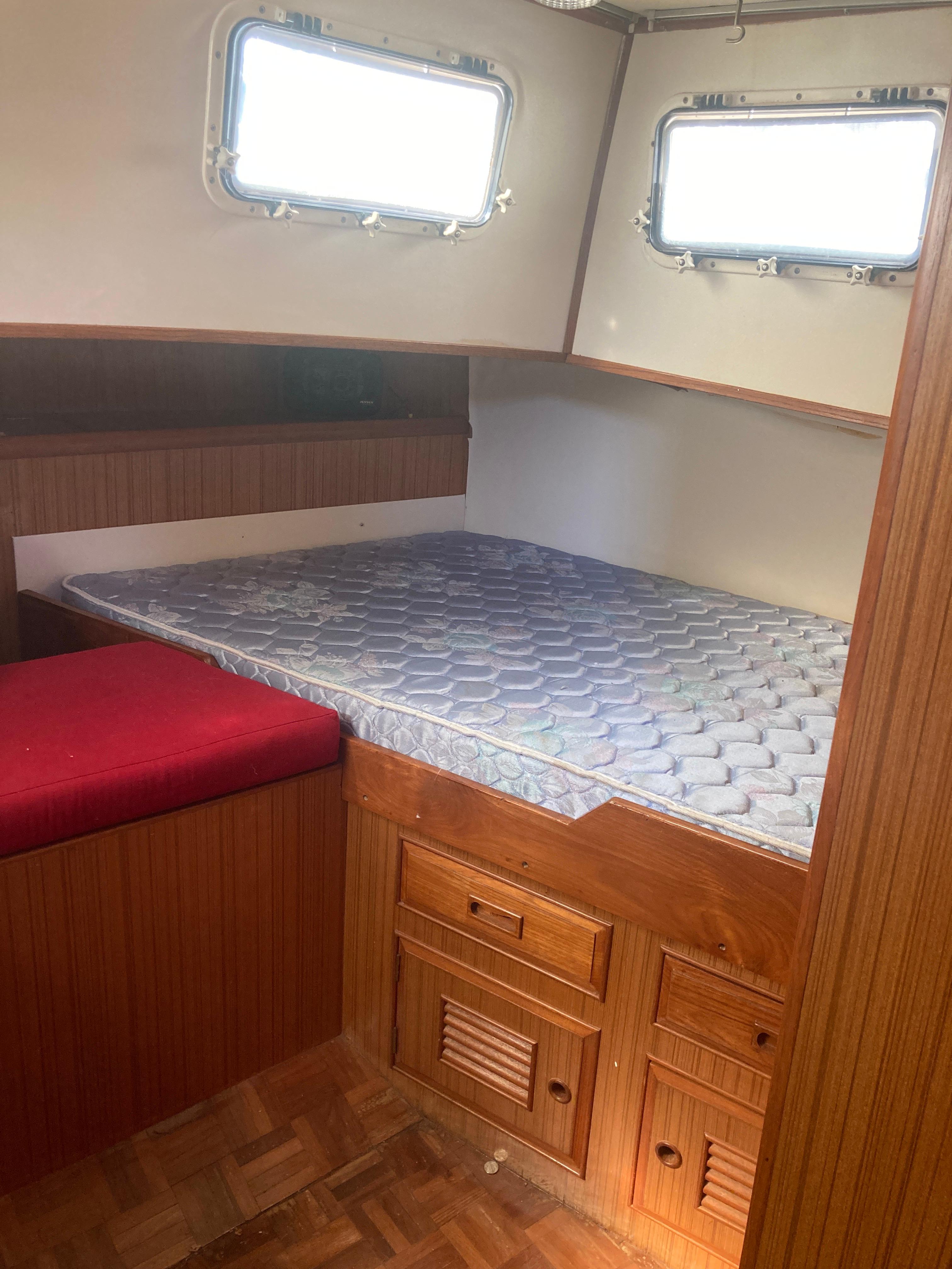 Slide: The Image of Interior cabin of 1981 Monk Comfort Monk Motorsailer 38 with bed, windows, and wooden storage. - 8