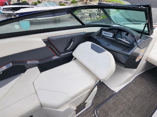 Slide: The Image of 2014 Monterey 234 Super Sport boat interior with white seating and Fusion stereo system. - 14