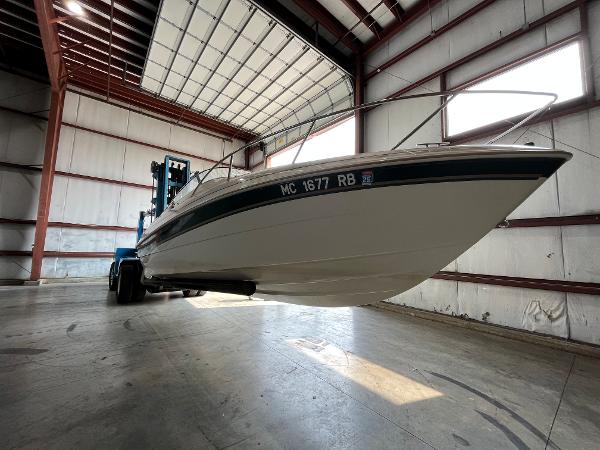 Slide: The Image of 1997 Monterey 236 Montura boat in a warehouse, lifted by a forklift. - 5