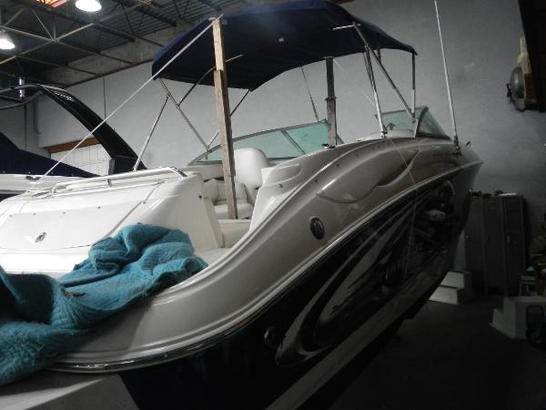 Slide: The Image of 2005 Monterey 248 LS boat with blue canopy in indoor storage. - 5