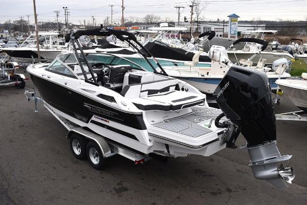 Slide: The Image of 2024 Monterey 275SS boat on trailer, black and white, outboard motor, marina background. - 4