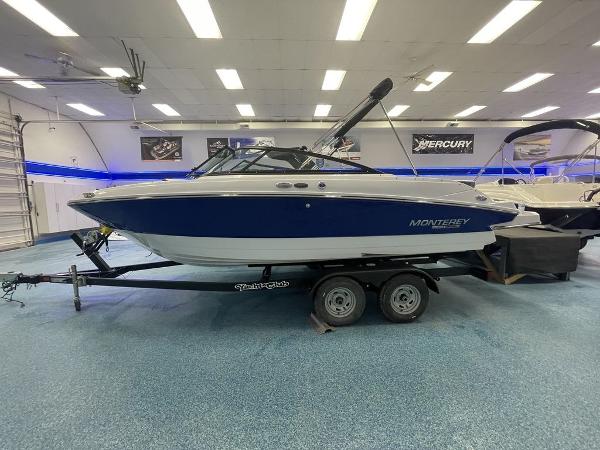 Slide: The Image of 2023 Monterey M-20 boat on trailer in showroom with blue and white exterior. - 1