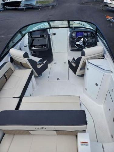 Slide: The Image of 2023 Monterey M-45 boat interior with beige and black seating, steering console, and storage compartments. - 7