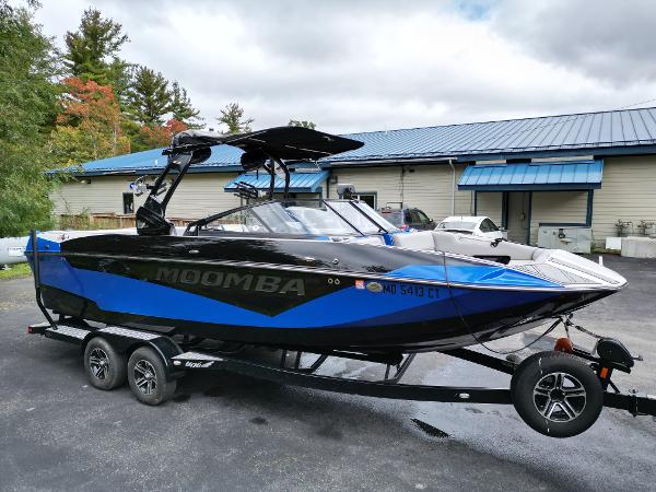 Slide: The Image of 2019 Moomba Makai boat on trailer, black and blue, parked outdoors. - 6