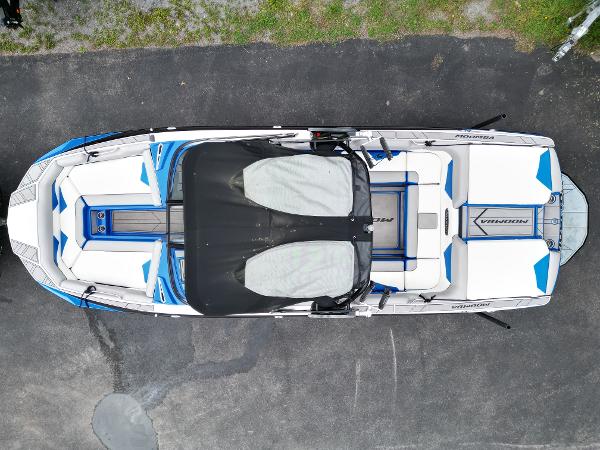 Slide: The Image of 2019 Moomba Makai boat, top view, white and blue interior, parked on asphalt. - 8