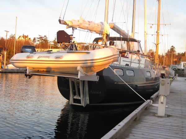 Slide: The Image of 1985 Nauticat 43 sailboat docked with dinghy, sunset lighting. - 11