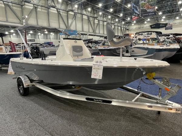 Slide: The Image of 2023 NauticStar 195 Bay boat displayed indoors on a trailer. - 0