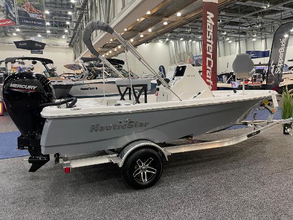 Slide: The Image of 2023 NauticStar 195 Bay boat displayed at an indoor boat show on a trailer. - 1