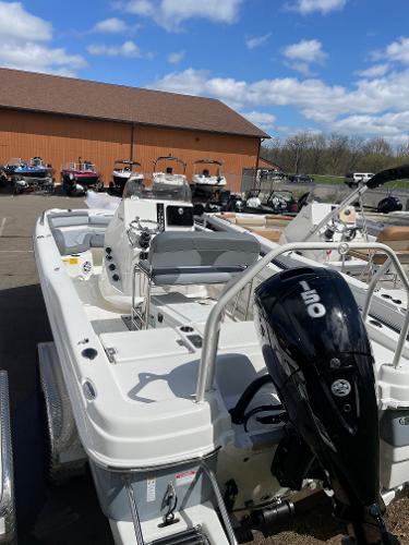 Slide: The Image of 2023 NauticStar 211 Hybrid boat with a 150 HP engine in a marina. - 1