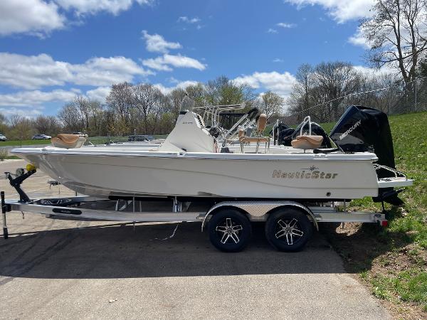 Slide: The Image of 2023 NauticStar 215 XTS boat on a trailer under a blue sky. - 1