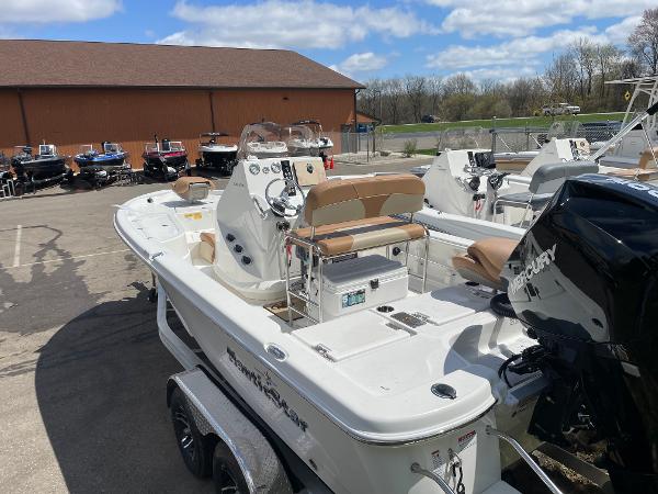 Slide: The Image of 2023 NauticStar 215 XTS boat with Mercury outboard motor in a dealership lot. - 2